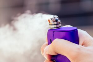 purple-vape-in-a-man-s-hand-on-a-modern-background-2024-10-31-04-18-19-utc-min